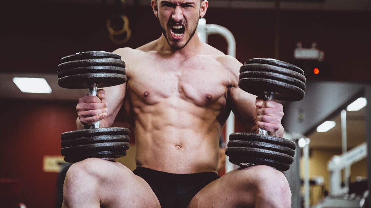 man holding two dumbbells